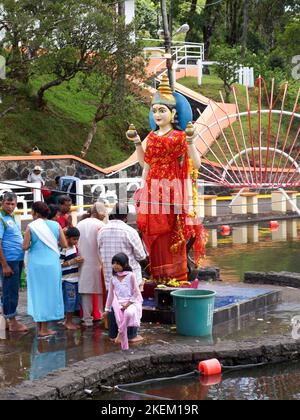 GRAND BASSIN, MAURITIUS - 24. FEBRUAR 2011: Statue der Hindu-Göttin Laksmi mit betenden Pilgern während des Hindu-Festivals von Maha Shivaratri in Stockfoto