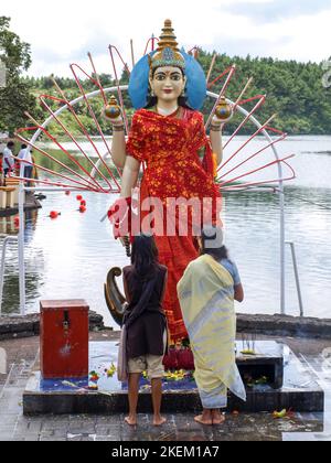 GRAND BASSIN, MAURITIUS - 24. FEBRUAR 2011: Mutter und Tochter beten während des Hindu-Festivals von Maha vor der Statue der Hindu-Göttin Laksmi Stockfoto