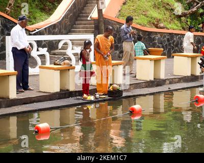 GRAND BASSIN, MAURITIUS - 24. FEBRUAR 2011: Mutter und Tochter bieten während des Hindu-Festivals von M Essen als rituelle Verehrung für ihren gott Shiva an Stockfoto