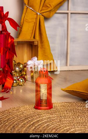 Das Innere eines Winterurlaubs, ein magisch leuchtender Weihnachtsbaum, elegante Geschenke mit roten Schleifen verziert Stockfoto