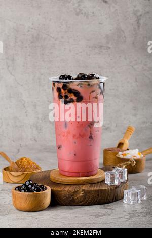Boba oder Tapioka Perlen ist taiwan Bubble Milch Tee in Kunststoff-Tasse mit rotem Samt Geschmack auf Textur Hintergrund, Sommer Erfrischung. Stockfoto