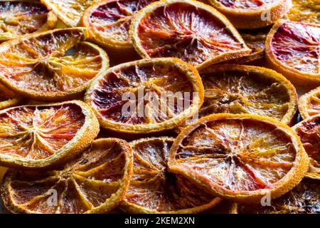 Nahaufnahme von getrockneten Blutorange-Scheiben mit Gewürzen und Zucker. Stockfoto