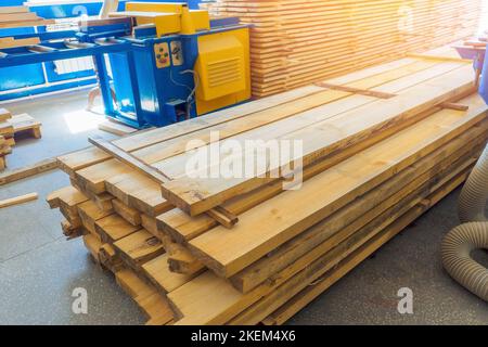 Viele Holzbretter in der Schreinerei gestapelt. Baumaterial. Hintergrund... Stockfoto