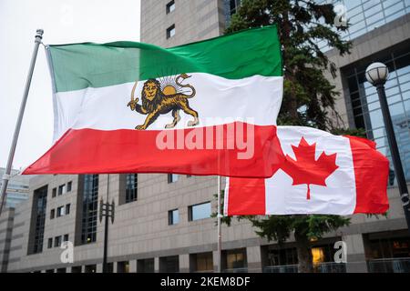 Kanadische und iranische shir-o-khorshid-Flaggen fliegen bei einem Ereignis in Toronto Seite an Seite, um sich mit iranischen Demonstranten solidarisch zu zeigen, die für ein Ende des Regimes kämpfen. Stockfoto