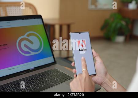 Chiang Mai Thailand. 09. Juli 2022. Frau mit Mobiltelefon, um Adobe Creative Cloud zu öffnen, um Arbeit, Foto, Video, Vorlage, PDF zu erstellen. Stockfoto