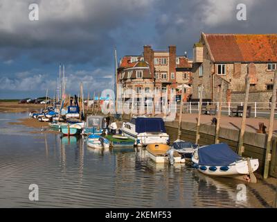 Das Küstendorf Blakeney an der North Norfolk Coast. An einem sonnigen Sommertag werden am Kai Freizeitboote vertäut. Stockfoto