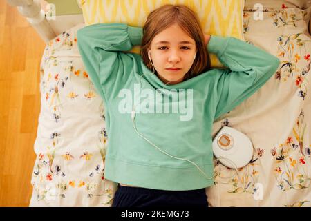 Teenager-Mädchen, das CD zeigt und Musik in ihrem Zimmer hört. Mädchen mit Retro-Spieler Stockfoto