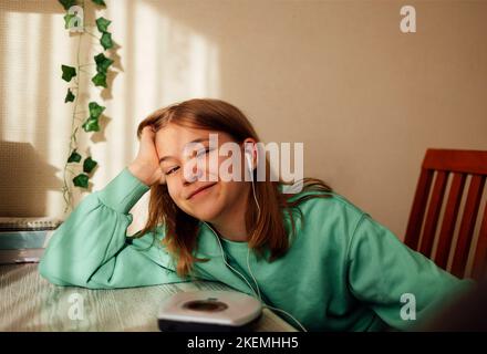 Teenager-Mädchen, das CD zeigt und Musik in ihrem Zimmer hört. Mädchen mit Retro-Spieler Stockfoto