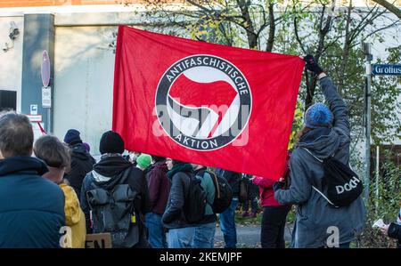 München, Bayern, Deutschland. 13.. November 2022. Demonstranten, die gegen die bayrischen PAGER Gesetze verstoßen, halten eine antifaschistische Aktionsflagge am Eingang des Gefängnisses in Stadelheim. Rund vier Jahre nach den massiven Protesten gegen das Polizeiaufgabengesetz, das der Polizei weitreichende Befugnisse zur Inhaftierung von Personen ohne Anklage gab und bevor Verbrechen begangen wurden, wurde das umstrittene Gesetz nach der Letzten Generation wieder in den Fokus gerückt. Klimaproteste, bei denen sich die Aktivisten an Fahrbahnen A kleben Stockfoto