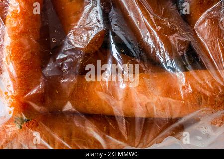 Rohe Karotten in Plastiktüte direkt aus dem Supermarkt Stockfoto