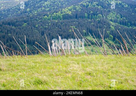 Bergzaun aus Holz auf dem Hügel, Frühlingsszene in den rumänischen Karpaten. Stockfoto