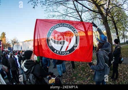 München, Bayern, Deutschland. 13.. November 2022. Demonstranten, die gegen die bayrischen PAGER Gesetze verstoßen, halten eine antifaschistische Aktionsflagge am Eingang des Gefängnisses in Stadelheim. Rund vier Jahre nach den massiven Protesten gegen das Polizeiaufgabengesetz, das der Polizei weitreichende Befugnisse zur Inhaftierung von Personen ohne Anklage gab und bevor Verbrechen begangen wurden, wurde das umstrittene Gesetz nach der Letzten Generation wieder in den Fokus gerückt. Klimaproteste, bei denen sich die Aktivisten an Fahrbahnen A kleben Stockfoto