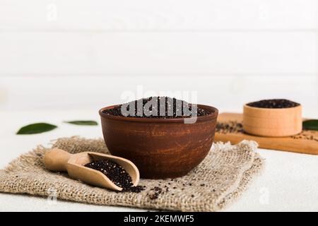 Quinoa-Samen in Schüssel und Löffel auf farbigem Hintergrund. Gesunde kinwa in kleiner Schüssel. Gesundes Superfood. Stockfoto