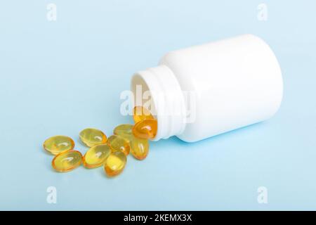 Omega-3 Kapseln liegen in einer weißen Flasche auf einem Tischhintergrund. Fischöl Tabletten Draufsicht. Biologisch aktive Zusatzstoffe. omega 6, Omega 9, Vitamin A, E, Stockfoto