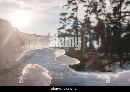 Nahaufnahme von Eisstücken und Schneeverwehungen im Winter. Stockfoto