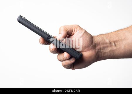 Hand und Arm eines Mannes, der ein Mobiltelefon mit einem leeren Bildschirm auf einem kernweißen Hintergrund hält. Stockfoto