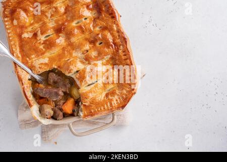 Englischer Rindersteak-Kuchen mit knusprigem Blätterteig in einer Backform Stockfoto