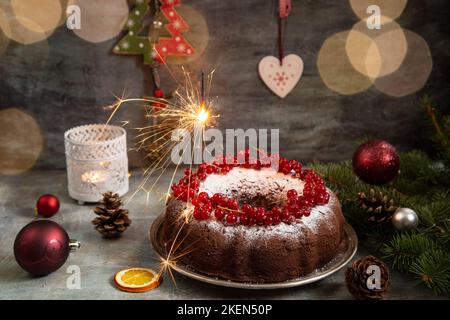 Weihnachtskuchen mit Dekoration und einem brennenden Funkeln Stockfoto