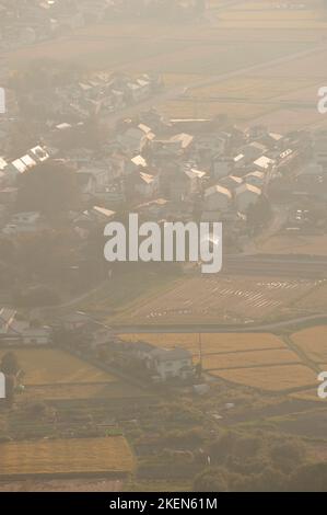 Die Mensumoto-Ebene von oben an einem trüben Herbsttag, mit Blick auf reife Reisfelder und verschiedene Gebäude. Stockfoto