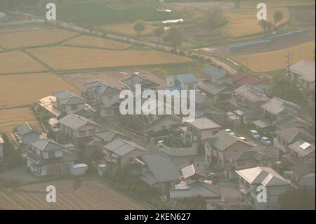 Die Mensumoto-Ebene von oben an einem trüben Herbsttag, mit Blick auf reife Reisfelder und verschiedene Gebäude. Stockfoto