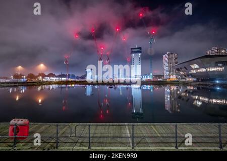 London, Großbritannien. 13.. November 2022. Kanada Wasser Masterplan Entwicklung Nachtbeleuchtung. British Land setzt sein Projekt fort, das Surrey Quays Shopping Centre, Surrey Quays Leisure Park, SE16 Druckwerke und die historischen Hafenbüros umfasst. Die ersten drei detaillierten Parzellen werden 269 neue Wohnungen – einschließlich erschwinglicher Wohnungen in verschiedenen Mietwohnungen – mit etwa 285.000 Quadratfuß Arbeitsfläche, einem potenziellen Freizeitzentrum, Geschäften und Restaurants bieten. Kredit: Guy Corbishley/Alamy Live Nachrichten Stockfoto