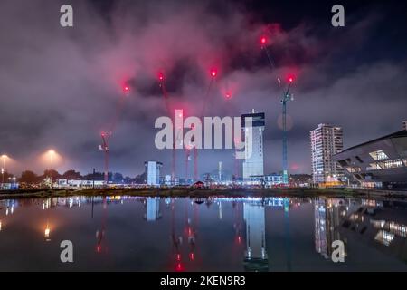 London, Großbritannien. 13.. November 2022. Kanada Wasser Masterplan Entwicklung Nachtbeleuchtung. British Land setzt sein Projekt fort, das Surrey Quays Shopping Centre, Surrey Quays Leisure Park, SE16 Druckwerke und die historischen Hafenbüros umfasst. Die ersten drei detaillierten Parzellen werden 269 neue Wohnungen – einschließlich erschwinglicher Wohnungen in verschiedenen Mietwohnungen – mit etwa 285.000 Quadratfuß Arbeitsfläche, einem potenziellen Freizeitzentrum, Geschäften und Restaurants bieten. Kredit: Guy Corbishley/Alamy Live Nachrichten Stockfoto