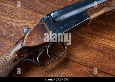 Antike 16-Gauge-Break-Action-Shotgun mit glatter Borte auf dem Holztisch. Stockfoto