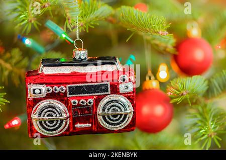 Ein weihnachtsschmuck in Form eines Radios oder einer Boombox, der am Weihnachtsbaum hängt. Stockfoto