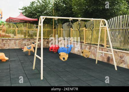 Verschiedene Kinderspielzeug auf dem Spielplatz. Schaukel Karussell im Park Stockfoto