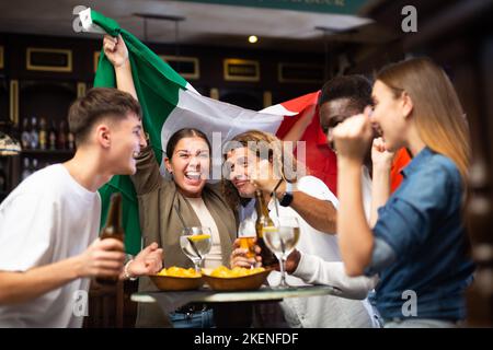 Eine Gruppe von Fußballfans der italienischen Mannschaft, die im Fernsehen ein Spiel in der Sportbar ansieht Stockfoto