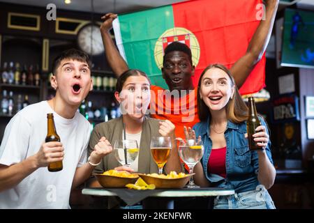 Begeisterte Fußballfans feiern den Sieg der portugiesischen Lieblingsmannschaft in der Sportbar Stockfoto