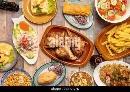 Peruanische Rezepte mit gefüllten Kartoffeln, gebratenes Huhn in Viertel geschnitten, Seebarsch Ceviche, Tamale mit lila Zwiebel, hausgemachte Pommes frites, Feldgericht Stockfoto