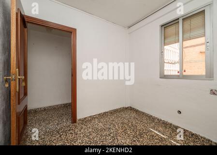 Leeres Zimmer mit hässlichem Vintage Terrazzo-Boden und Aluminiumfenster Stockfoto