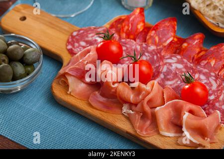 Spanische leckere Mahlzeit Würste und Jamon mit Tomaten schneiden, Nahaufnahme Stockfoto