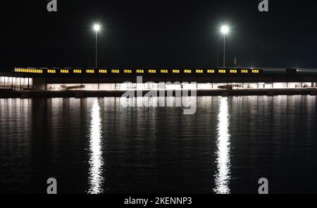 Abstraktes Muster, das von Flutlichtern an einem Kai erzeugt wird und Reflexionen auf dem Wasser erzeugt Stockfoto