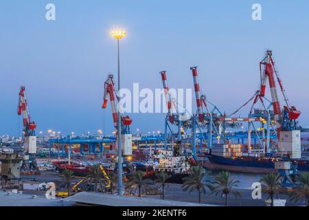 Containerkrane auf dem Dock und angedockte Frachtschiffe bei Sonnenaufgang im Hafen von Ashdod, Israel. Stockfoto