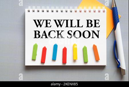 Text We'll Be Back Soon geschrieben auf Holzrahmen. Stockfoto