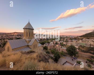 Sommer Sonnenuntergang Blick vom Heiligen Berg Mtasminda mit St. Nikolaus orthodoxe Kirche befindet sich im unteren Hof der Festung Narikala im Vordergrund und Stockfoto