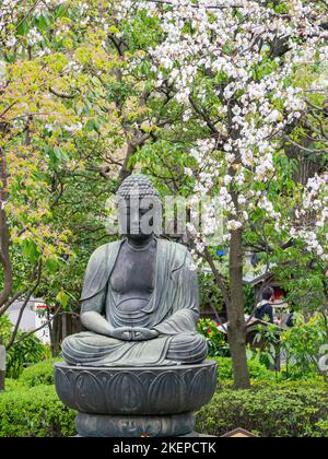 Tokio, APR 6 2013 - Nahaufnahme einer buddhistischen Statue mit Kirschblüte Stockfoto