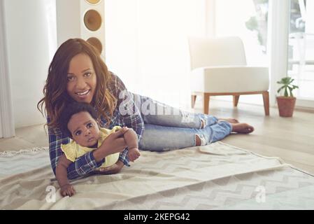 Sie bedeutet mir die Welt. Ganzkörperaufnahme einer jungen Mutter und ihres kleinen Mädchens zu Hause. Stockfoto