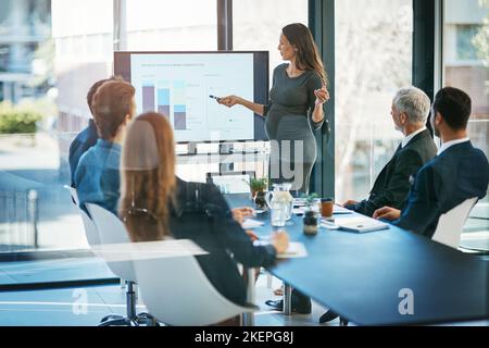 Ihre Präsentation. Aufnahme einer Schwangeren Geschäftsfrau, die im Sitzungssaal eine Präsentation gehalten hat. Stockfoto