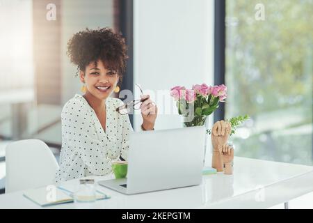 Ich halte meine Kunden für mehr zurück. Eine schöne junge Geschäftsfrau, die hinter ihrem Laptop sitzt. Stockfoto