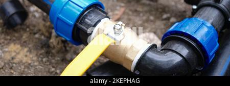 Wasserleitungsanschluss mit Wasserhahn in der Nähe für die Bewässerung von Pflanzen im Garten Stockfoto