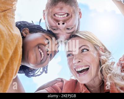 Glücklich, lächeln und interracial Familie Umarmung von Mutter, Vater und Mädchen Gesichter im Freien mit Liebe und Sorgfalt. Glück, Lachen und Sommer Spaß Huddle von a Stockfoto