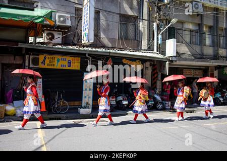 New Taipei, Taiwan. 13.. November 2022. Die Darsteller sahen, wie sie während der Parade Regenschirme unter der Sonne hielten. Eine religiöse Parade, die von lokalen Tempeln im Raum Taipei durchgeführt wird, um den Jahrestag der Tempel zu feiern und als politische Kampagnen für die bevorstehenden Kommunalwahlen in Taiwan zu dienen. Kredit: SOPA Images Limited/Alamy Live Nachrichten Stockfoto