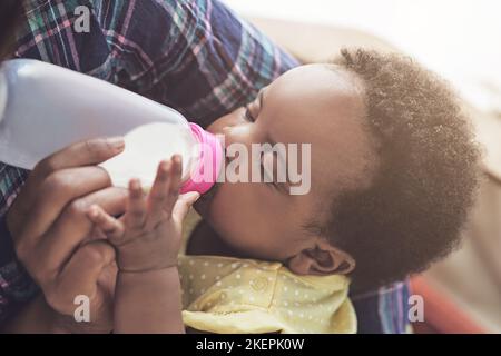 Sicherstellen, dass sie alle Nahrung bekommt, die ein wachsendes Baby braucht. Eine Mutter füttert ihr Baby zu Hause. Stockfoto