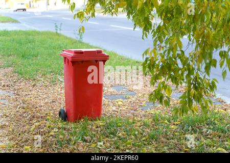 Umweltkonzept. Es gibt einen roten Plastikmüll auf der Straße. Stockfoto