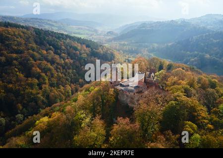 Luftaufnahme von oben auf Schloss Grodno in Zagorze mit schöner Herbstlandschaft. Alte historische Festung in den Bergen, mit Wald bedeckt. Polen landmar Stockfoto