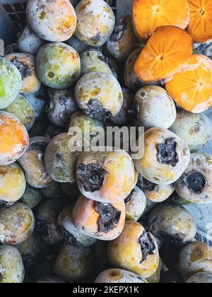 Lokale persimmon kesemek diospyros an einem Obststand in indonesischen traditionellen Markt Stockfoto