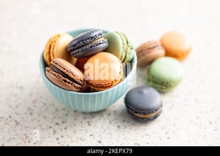 Süßes Makronen-Dessert. Bunte Makronen in Schale auf dem Küchentisch. Stockfoto